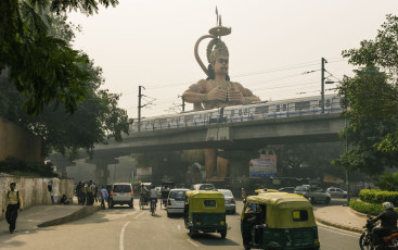 Eine riesige Statue der Hindu-Gottheit Hanuman erhebt sich über den Verkehr in einer belebten Straße Neu Delhis. Hanuman ist eine der Hauptfiguren in der hinduistischen Ramayana-Mythologie und einer der am meisten verehrten Götter des hinduistischen Glaubens