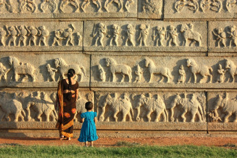 Ein Mutter mit Kind bewundert die Steinreliefs in Hampi, dem Zentrum des hinduistischen Vijayanagara-Reiches.