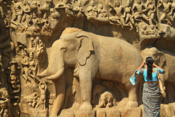 Eine Dame fotografiert ein Elefantenrelief aus dem 9. Jahrhundert an der Felswand von Arjuna's Penance in Mamallapuram.