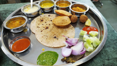Das köstliche Maharaja Thali wird auf einer großen runden Platte serviert und besteht aus Fladenbrot, Linsen, Gemüse und Chutney. Rajasthan ist berühmt für seine köstlichen Thalis - Foto von Harshit Srivastava S3
