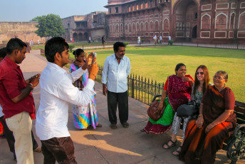 Einheimische machen ein Foto mit einem ausländischen Touristen und Mitgliedern ihrer Familie im Fort Agra. Das Fort diente bis 1638 als Hauptresidenz der Mogulherrscher und wird wegen des für den Bau verwendeten roten Sandsteins oft als Rotes Fort bezeichnet - Foto von  Don Mammoser