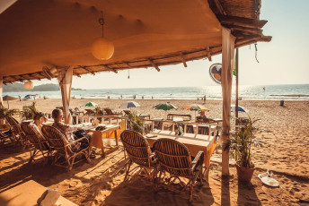 Touristen genießen eine Mahlzeit in einem Strandrestaurant in Goa. Der Bundesstaat ist berühmt für seine unberührten Strände und hat eine ausgedehnte Küstenlinie - Foto von Radiokafka