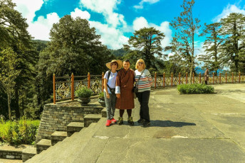 Ausländische Touristen posieren mit einem Bhutaner Tour-Guide in traditioneller Kleidung im Druk Wangyal Lhakhang-Tempel am Dochula-Pass, Bhutan