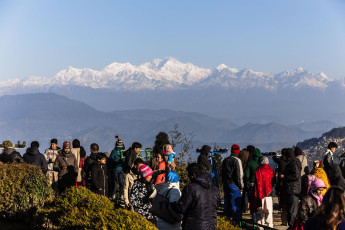 An einem kalten Wintermorgen versammeln sich Besucher auf dem Tiger Hügel bei Darjeeling, um den Sonnenaufgang am Neujahrstag zu erleben. Von diesem Aussichtspunkt aus bietet sich ein spektakulärer Blick auf Bergdörfer und den mächtigen Berg Kangchenjunga © Artitwpd