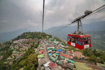 Reisende in einer Seilbahn bewundern Gangtok von oben und haben einen wunderbaren Ausblick auf die umliegenden Berge © Aliaksandr Mazurkevich