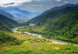 Die wunderschöne Landschaft des Punakha-Tals ist mit Reisfeldern und dicht bewaldeten Hügeln bedeckt und bietet atemberaubende Ausblicke auf die Berge. Bhutan wird als ein irdisches Paradies beschrieben, besonders für Naturliebhaber © Maurice Brand
