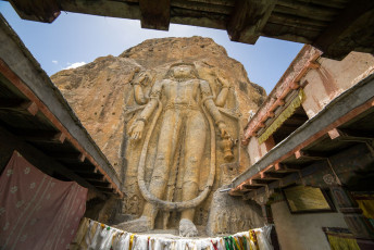 Ein beeindruckendes, riesiges Abbild des Maitreya (zukünftiger Buddha), das in eine massive Felsplatte im Dorf Mulbekh in der Nähe von Leh, Ladakh, gemeißelt wurde. Es überblickt die alte Handelsroute und die heutige Straße und stammt aus dem achten Jahrhundert. - Foto von Mazur Travel