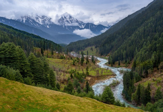 Die wunderschöne Landschaft mit grünen Bäumen, schneebedeckten Bergen und dem Fluss erblickt man bei einer Fahrt von Pahalgam ins Aru-Tal. Diese Region wird als "Himmel auf Erden" bezeichnet und ist bei Besuchern, die durch Jammu und Kaschmir reisen, sehr beliebt. - Foto von Supermop