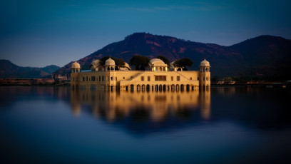 Das Jal Mahal aus hellem Sandstein, einst das Jagdschloss der Maharadschas, thront königlich in der Mitte des Man Sagar Sees in Jaipur. Vier der fünf Stockwerke befinden sich unter Wasser, wenn das Wasser des Sees ansteigt © BUSINESS-CREATIONS / Shutterstock