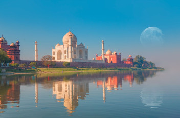 Das berühmte Taj Mahal, ein historisches Mausoleum aus Marmor, spiegelt sich bei Sonnenuntergang wunderschön im Yamuna-Fluss in Agra © muratart