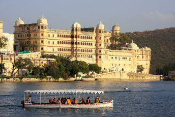 Besucher von Udaipur bewundern den Stadtpalast von einem Boot auf dem Pichola-See aus. Der Palastkomplex wurde über einen Zeitraum von 400 Jahren von aufeinander folgenden Mewar-Herrschern errichtet und ist der größte in ganz Rajasthan.