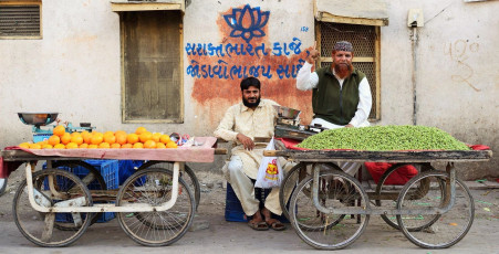 Moslems verkaufen in den Straßen der Stadt Junagadh im indischen Staat Gujarat Früchte von einer Karre - Foto von Rafal Chichawa