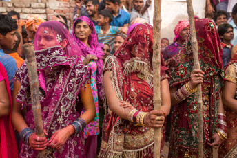 In Nandgaon, Indien, schlagen die Frauen zum Lathmar-Holi-Fest die Männer spielerisch mit Stöcken. © Mazur Travel / Shutterstock