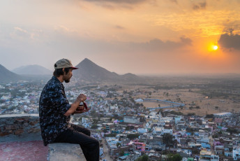Vor dem Hintergrund eines wunderschönen Sonnenuntergangs über der Stadt Pushkar, bringt dieser Mann mit seiner tibetanischen Klangschale faszinierende Töne hervor. © Bruno Mogli Gilioli / Shutterstock