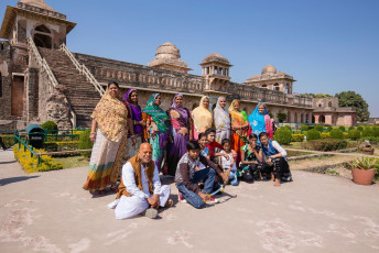 Eine Gruppe von Touristen posiert für die Kamera vor dem Jahaz Mahal, auch Schiffspalast genannt, in Madhya Pradesh. Die Spiegelung des Gebäudes im umliegenden Stausee ähnelt dem Abbild eines riesigen Schiffes.