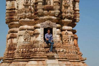Ein Besucher sitzt in einem Fenster der kunstvoll geschnitzten Kirti Stambha (des Turms des Ruhms) im Chittorgarh Fort aus dem 12. Jahrhundert. Eine schmale Treppe führt die sieben Stockwerke hinauf zu einem Aussichtsplatz an der Spitze, von dem aus man einen spektakulären Ausblick auf die Umgebung hat.