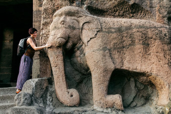 Ein Tourist bewundert die Steinskulptur eines Elefanten in den Ajanta-Höhlen bei Aurangabad. Die Gruppe von rund 30 in den Fels gehauenen Höhlen beherbergt einige der anschaulichsten Beispiele altindischer Malereien und Skulpturen.
