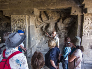 Ein Tour-Guide erklärt die Geschichte und die Bedeutung der Steinmetzarbeiten in einem der Ellora-Höhlentempel in der Nähe von Aurangabad. Die ältesten Tempel der Gruppe gehen auf das Jahr 500 v. Chr. zurück.