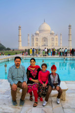 Eine Besucherfamilie ruht sich vor dem Taj Mahal in Agra, Indien, aus. Prinzessin Diana wurde einst auf dieser Bank sitzend fotografiert. Seit 1983 ist das Taj Mahal ein UNESCO Weltkulturerbe. © Don Mammoser / Shutterstock