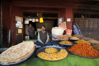 Ein Mann erwartet seine Kunden mit seinen traditionellen kaschmirischen Süßigkeiten, die in seinem Laden in Srinagar ausgestellt sind. © CRS FOTO
