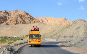 Ein Schulbus fährt in großer Höhe auf der Ladakh-Leh-Straße im Himalaya - Foto von Phuong D Nguyen