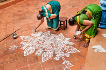 Zwei tamilische Frauen malen zur Feier des Pongal-Erntefestes in Chettinad kunstvolle Muster vor ihrem Haus. Während des viertägigen Festes zeigen die Menschen ihre Dankbarkeit gegenüber Lord Indra und der Sonnengottheit