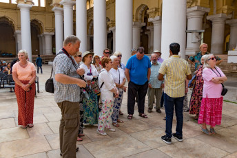 Ein einheimischer Tour-Guide mit einer Gruppe ausländischer Touristen im Tirumalai Nayak Palace in Madurai. Der Palast ist eine klassische Mischung aus Rajput- und italienischem Baustil