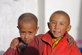 Zwei junge buddhistische Mönche, die sich gegenseitig die Hände auf die Schultern legen, stehen vor dem Kloster Thiksey © Pavel Svoboda