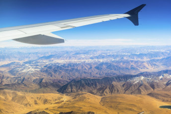 Ein Flugzeug überfliegt die hohen Berge  auf dem Weg von Leh nach Neu-Delhi © Teradat Santivivut