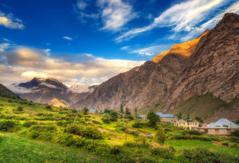 Grüne Felder bilden einen schönen Kontrast zu den schroffen Bergen des Lahaul-Tals in Himachal Pradesh. Das Dorf Jispa schmiegt sich an den Fuß der Berge © structuresxx