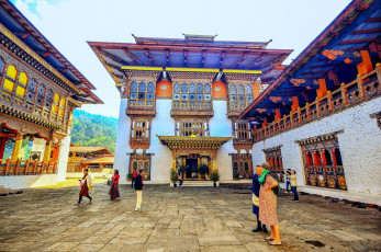 Ausländische Besucher im schönen Innenhof des Punakhu Dzong, Bhutan. Diese Klosterfestung gilt als die majestätischste des Königreichs. Das sechsstöckige Bauwerk steht zwischen den Flüssen Mo Chhu und Po Chhu © rabbito