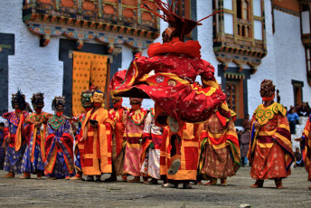Tänzerinnen und Tänzer in farbenprächtigen Kostümen versammeln sich für eine traditionelle Mongar-Maskentanzvorführung.  Dieses dreitägige religiöse Tshetsu-Festival findet einmal im Jahr am Mongar Dzong statt und zieht Menschen aus ganz Bhutan und dem Ausland an © lakkana savaksuriyawong