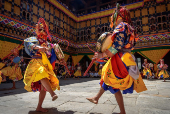 Zwei buddhistische Mönche schlagen ihre Trommeln während des jährlichen Maskentanzfestes in Paro. Dieses wichtige religiöse Fest findet in ganz Bhutan in verschiedenen Klöstern und Dzongs statt © Maurice Brand