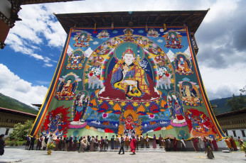 Klösterliche Festungen, Dzongs genannt, sind in ganz Bhutan zu finden und Schauplatz der jährlichen, dreitägigen Tshechu-Festivals. Auf dem Bild helfen Personen den Mönchen beim Aufrollen der riesigen Thangka. Die Enthüllung dieses riesigen religiösen Bildes ist ein Höhepunkt der Feierlichkeiten und findet am letzten Tag des Festes statt © Jiali Chen