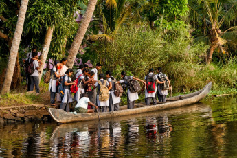 Ein ganz normaler Tag für Schulkinder, die eine Bootsfahrt durch die Backwaters von Alappuzha machen, um nach Hause zu kommen. © cornfield.