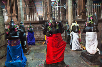 Gläubige schmücken alte Götterfiguren im Meenakshi-Tempel in Madurai mit Blumen und bunten Kleidern © saiko3p