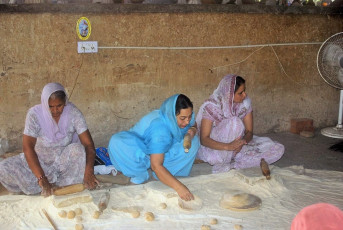 Sikh-Damen bereiten Roti in der Gemeinschaftsküche des Goldenen Tempels in Amritsar zu - Foto von Attila Jandi