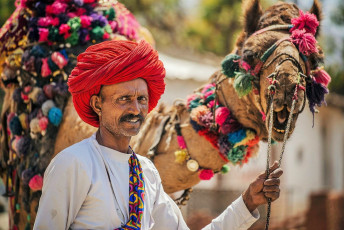 Ein Mann und sein Kamel posieren bei der Pushkar Camel Fair - Foto von costas anton dumitrescu