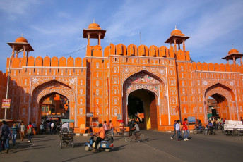 Ein paar Leute gehen durch das Ajmeri-Tor in Jaipur, Indien. Dieses ist ein wunderschönes Monument, das man am besten mit einem Tuk Tuk erkundet, da der Verkehr normalerweise ein Chaos ist. © Don Mammoser
