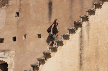 eine touristin auf der treppe im massiven bundi-palast in rajasthan. Der palast ist berühmt für seine prächtigen türkisfarbenen und goldenen wandmalereien © don mammoser