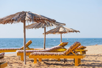 Exotische Strandschirme und -stühle an der tropischen Küste von Goa - Foto von Anatoli Styf