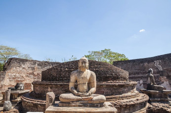 Eine der vier Buddha-Statuen, die in Vatadage (Polonnaruwa) aus dem Fels gehauen wurden. Jede Statue ist in eine andere Richtung ausgerichtet. Von den ursprünglich vier Statuen sind zwei annähernd unversehrt erhalten © calvste