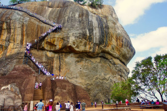 Touristen, die in den frühen Morgenstunden den Löwenfelsen von Sigiriya erklimmen. Die historische Felsenfestung von Sigiriya, auch Löwenfelsen genannt, in der Nähe von Dambulla, Sri Lanka, ist eine Stätte von historischer und archäologischer Bedeutung. Sie gehört auch zum Weltkulturerbe der UNESCO - Foto: Edison Apolonio