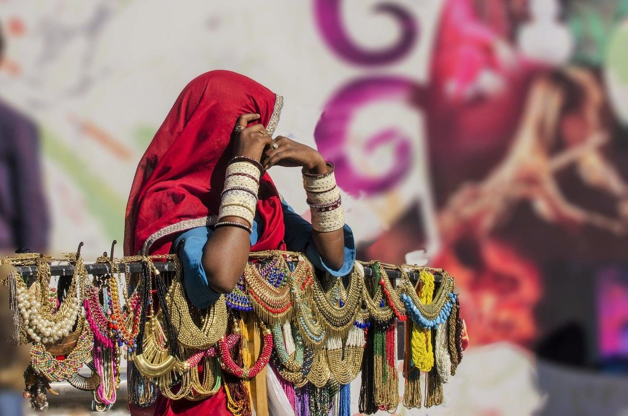 Frau in traditionell indischem Sari verkauft schmuck