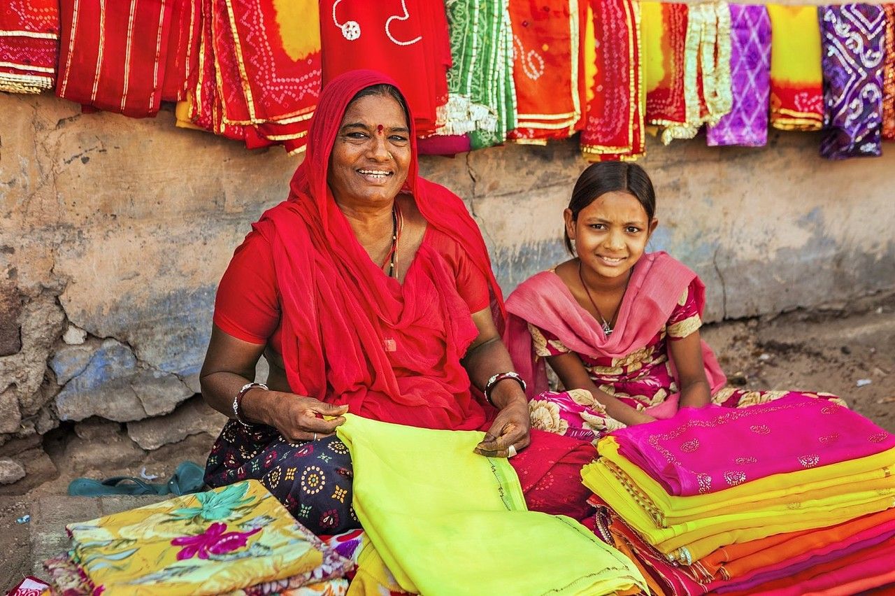 Indische Frau und ihre Tochter verkaufen farbige