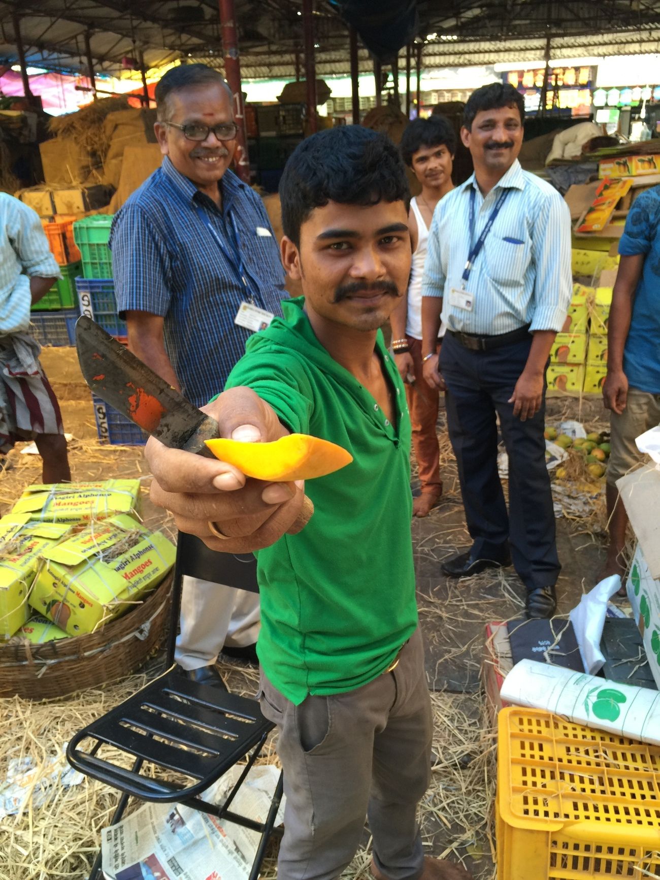 ein obstverkäufer im crawford market area bietet ein stück alphonso-mango an
