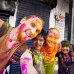 Touristen und indische Kinder Holi-Fests
