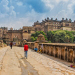 Sadhu sitzt am Eingang des Komplexes Orchha Fort